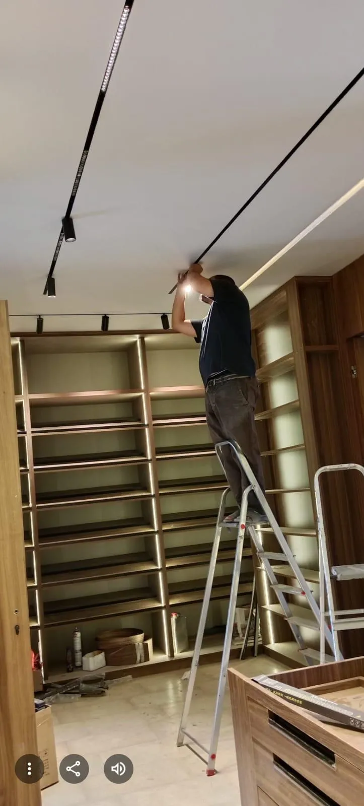 Installation de spots sur rail au plafond d'un magasin